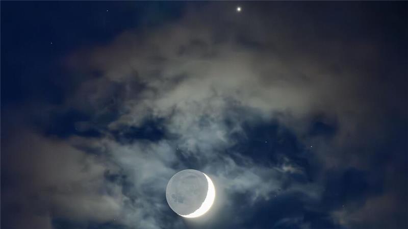 Sonne, Mond und Sterne im März - Mond- und Sonnenfinsternis Die Mondsichel zusammen mit der Venus (am oberen Bildrand).