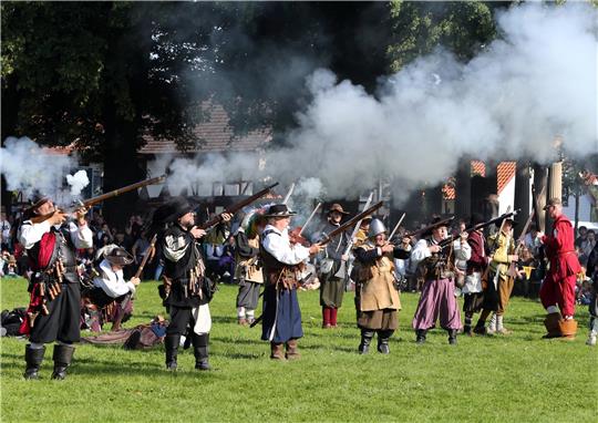 Die Musketiere legen an und feuern unter reichlich Pulverdampf einige Salven in den blauen Himmel über der Stadt.  Foto: Neuendorf
