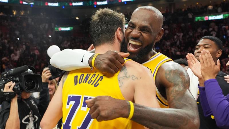 Die NBA-Stars Luka Doncic (l) und LeBron James von den Los Angeles Lakers umarmen sich nach ihrem Sieg gegen die Miami Heat.