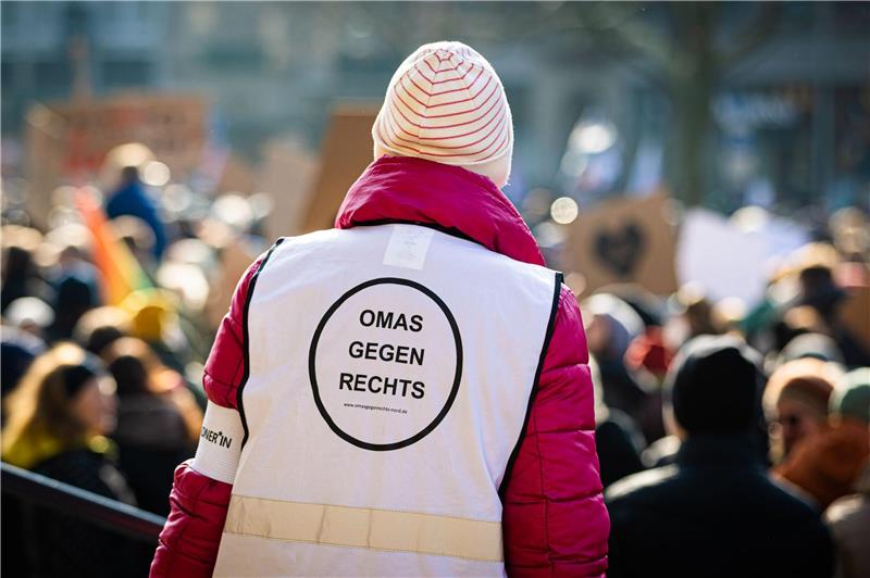 Eine Frau trägt eine Weste mit der Aufschrift "Omas gegen Rechts".