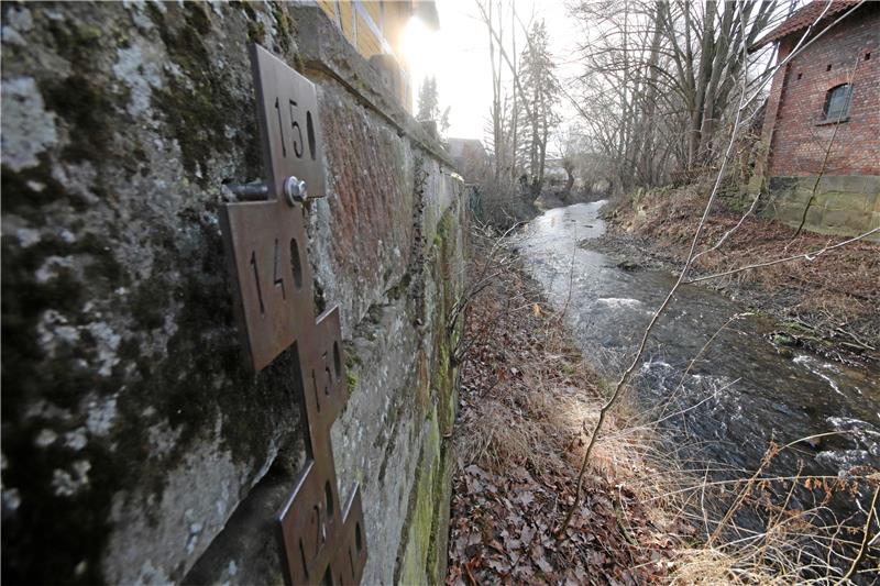 Wann wird Neuwallmoden sicherer vor Flutwellen? Die Pegellatte an der Brücke in der Dorfmitte reicht bis zu einem Wasserstand von 1,50 Metern. Ab etwa 1,20 Metern wird es kritisch, dann stößt die Neile an die Unterkante des Brückenbauwerks und staut sich zurück, um dann flussaufwärts über die Ufer zu treten und das Dorf zu überfluten. Bei den schweren Hochwassern der Jahre 2017 und 2018 war die Latte nahezu komplett in den Neile-Fluten verschwunden. Foto: Gereke