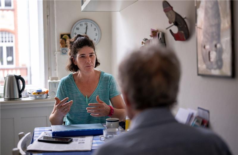 Die Pflegerin Ramona Rössner spricht beim Hausbesuch mit ihrem pflegebedürftigen Patienten Andreas Seltzer.