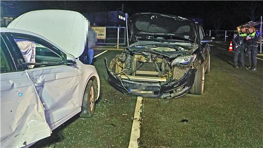 Zwei stark beschädigte Autos stehen nach einer nächtlichen Kollision auf einer Straße.