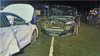 Zwei stark beschädigte Autos stehen nach einer nächtlichen Kollision auf einer Straße.