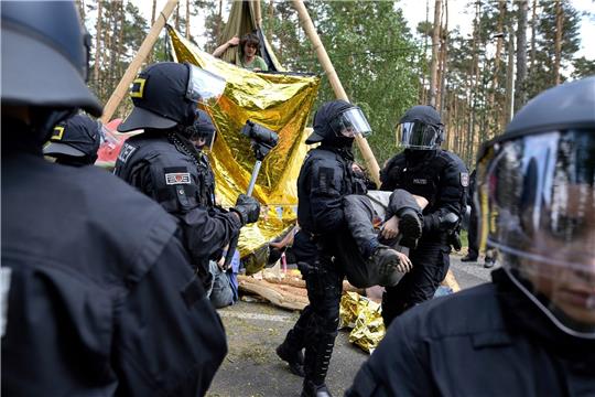 Die Polizei löst eine Straßenblockade auf.