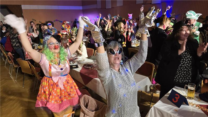 Feiern und Feste: Die Kaiserstadt in jeder Jahreszeit erleben Das Foto zeigt verkleidete Besucher, die jubelnd beim Karneval im Lindenhof feiern.