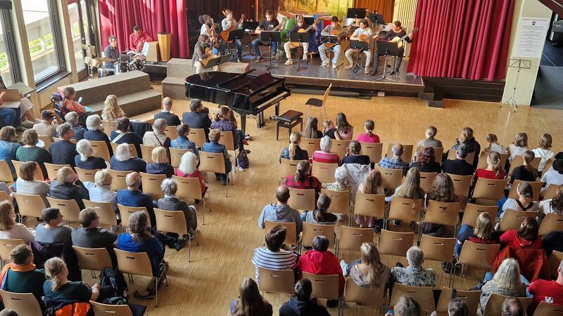 Die RKS-Aula ist gut gefüllt. Auf der Bühne spielt das Gitarrenensemble.