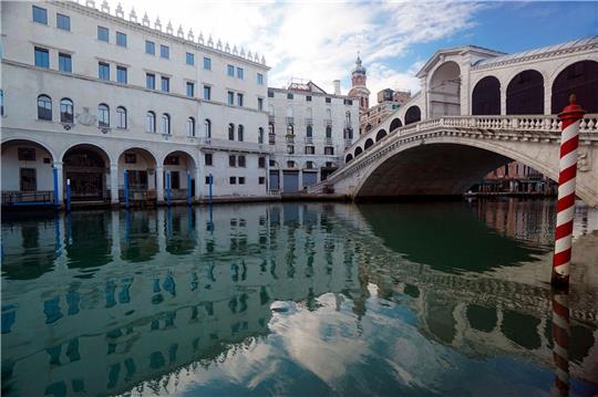 Die Rialto-Brücke spiegelt sich im Canal Grande.