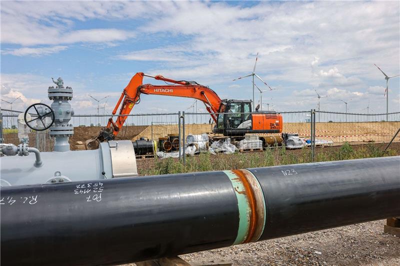 Wasserstoff-Autobahn in den Startlöchern Die Rohre einer künftigen Wasserstoffleitung liegen vor der Kulisse eines Windparks.