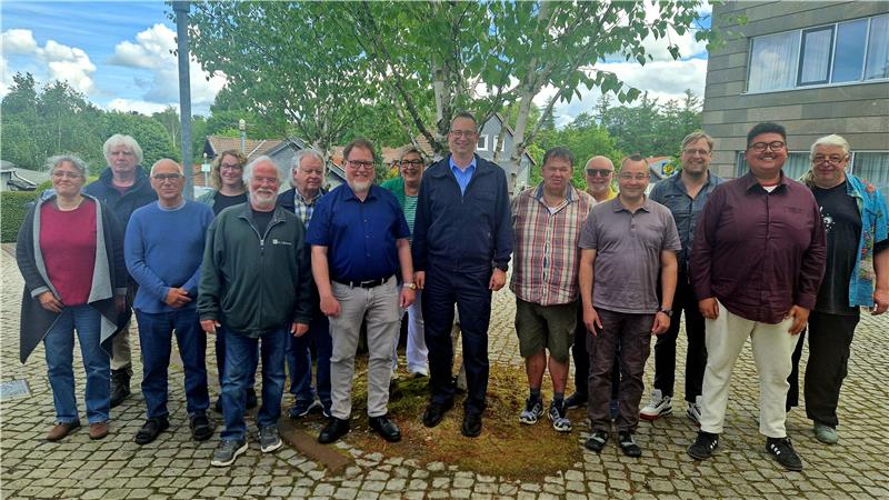 15 Menschen stehen nebeneinander.