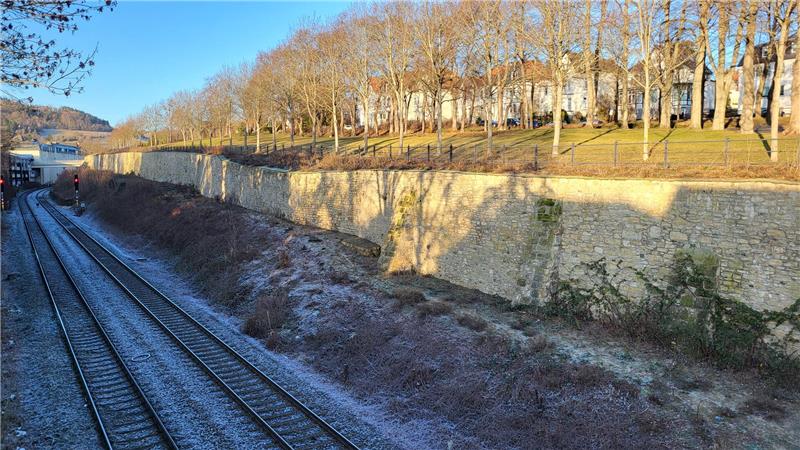 Das Bild zeigt die Bahnmauer in Goslar. Links im Bild sind die Bahngleise zu sehen.