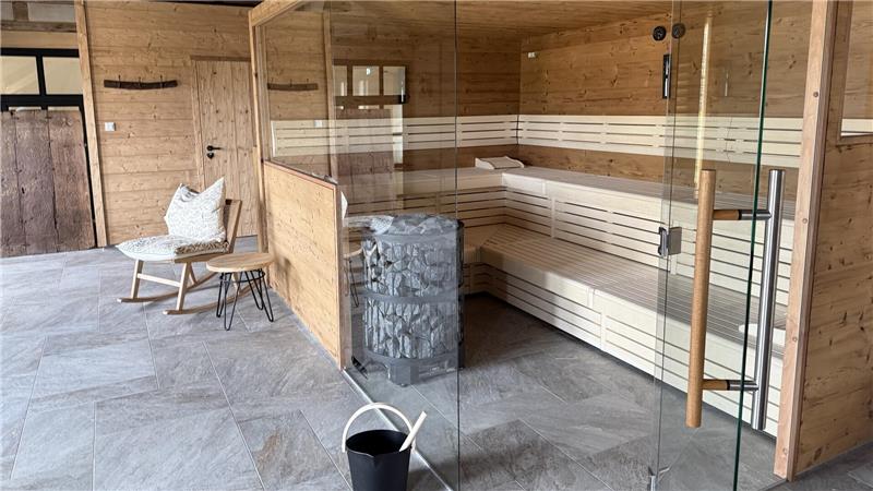 Das Foto zeigt eine Saune mit Eimer und Schaukelstuhl.