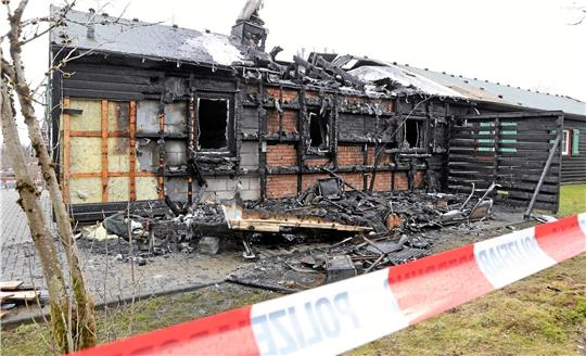 Die Schäden an dem Ferienhaus (Foto) und dem komplett zerstörten Wohnwagen schätzt die Polizei auf etwa 100.000 Euro. Das rot-weiße Flatterband weist auf die Ermittlungen der Polizei hin. Derzeit können die Beamten aber noch nichts Genaues zur Brandursache sagen. Fotos: Neuendorf