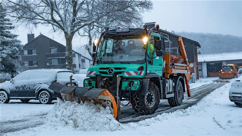 Das Foto zeigt einen Schneepflug, der Schnee räumt.