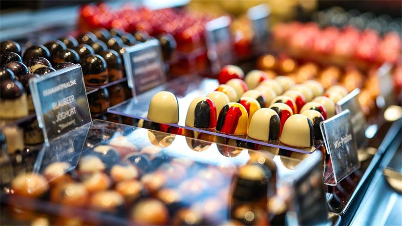 Schoko-Produktion fürs Weihnachtsgeschäft im vollen Gang Die Schokoladenmasse wird in kleine Formen gegossen und gehärtet.