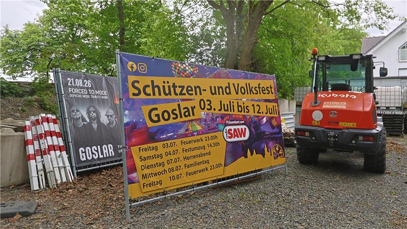 Werbebanner für das Schützen- und Volksfest Goslar vom 3. bis 12. Juli neben einem roten Kubota-Bagger auf einem Schotterweg.