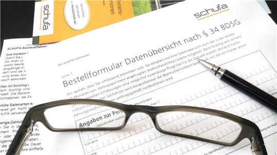 Brille liegt auf einem Formular mit der Überschrift 'Bestellformular Datenübersicht nach § 34 BDSG' und einem Kugelschreiber daneben
