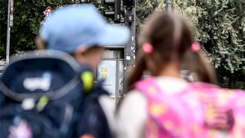 Die Schulanfänger Edgar (6) und Angelina (5) stehen an einer Straße am Rande der Schulanfangskampagne „Achtung Schulweg! Sicher starten, sicher ankommen“ in Berlin.