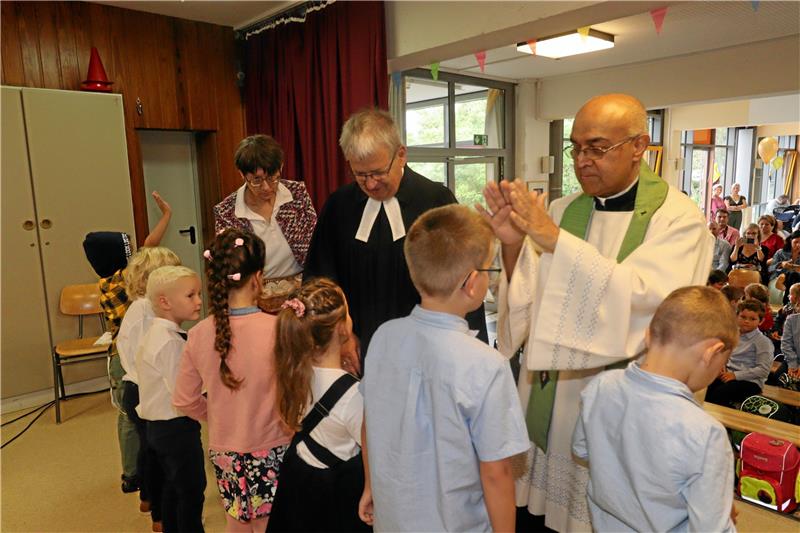 Kinder erhalten zum Schulstart einen Segen Die Schulanfänger erhalten während der Einschulungsfeier auch eine Segnung und Fürbitte vom evangelischen Pfarrer Dirk Glufke und katholischen Pater Cyriac Chandrankunnel (v. li). Foto: Jambrek
