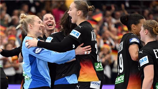Mehrere Handballspielerinnen umarmen sich nach einem Spiel in einer Halle