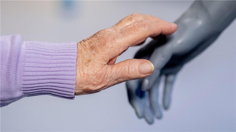 Die Senioren testen, wie sich der Roboter anfühlt. 