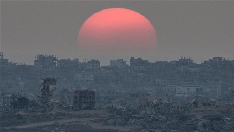 Die Sonne geht hinter Gebäuden unter, die bei israelischen Boden- und Luftangriffen im Gazastreifen zerstört wurden, gesehen vom Süden Israels aus.