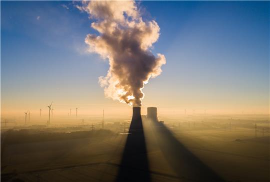 Die Sonne geht hinter einem Kohlekraftwerk auf und taucht Windkraftanlagen in noch dunstiges Licht: Das Foto aus dem Landkreis Peine soll die Herausforderungen symbolisieren, die Energiekrise und Klimaschutz abfordern.  Foto: dpa