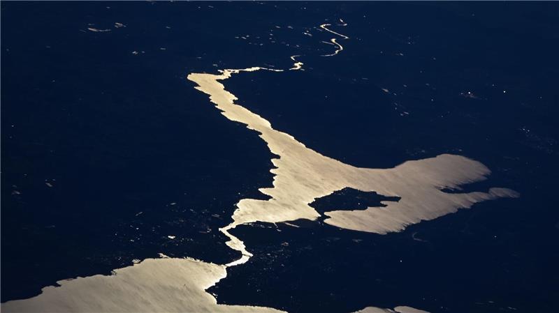 Die Sonne reflektiert sich im Bodensee, während die Stadt Konstanz, die Inseln Reichenau und Mainau sowie der Untersee und der Rhein zu sehen sind. (Aufnahme aus einem Flugzeug)