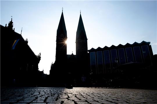Die Sonne scheint hinter den Türmen des Sankt-Petri-Doms am Bremer Marktplatz.