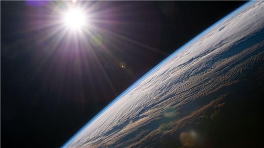 Die Sonne scheint über dem Horizont der Erde, während die Internationale Raumstation über der kanadischen Provinz Quebec kreist.