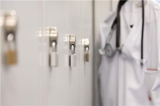 Die Spinds der Mitarbeiter in einem Krankenhaus sind mit Vorhängeschlössern verschlossen.