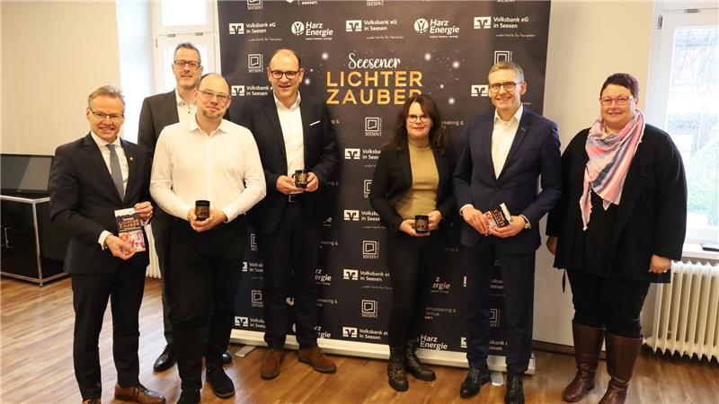 Die Sponsoren des Seesener Lichterzaubers sowie die Geschäftsführer von Stadtmarketing und Wirtschaftsbetriebe stehen vor einem Banner des Lichterzaubers.