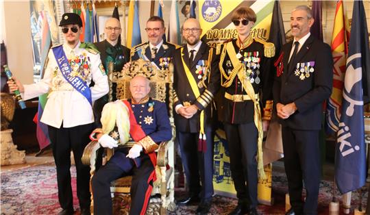 Die Staatsoberhäupter präsentieren sich vor den Flaggen ihrer Mikronationen.