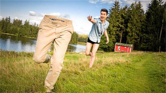 Ein Mann läuft nur mit Unterhose und Hemd bekleidet hinter einer Hose her.