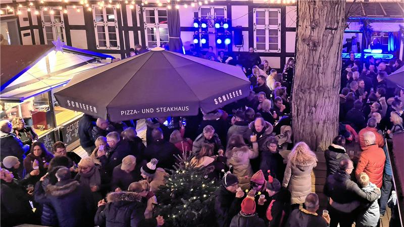 Viele Weihnachtsmärkte öffnen vor Totensonntag – Goslar nicht Viele Leute stehen auf einer beleuchteten Fläche im Hinterhof des Hotels Schiefer.