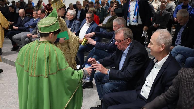 Kinder in Sternsinger-Kostümen sammeln Geld von Menschen.