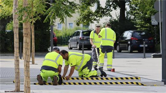 Die Stolperkante wird sichtbar gemacht und mit gelb-schwarz gestreiftem Band beklebt.