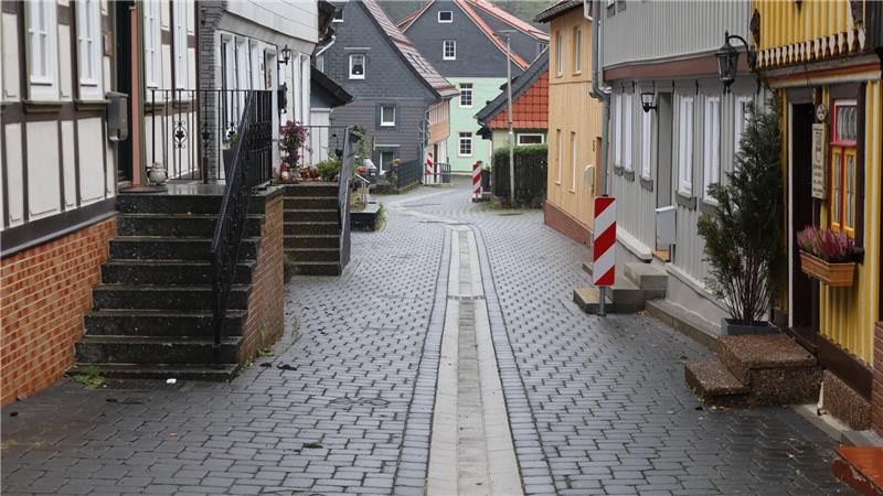 EIne schmale Straße an der links und rechts Häuser und Eingänge sind.