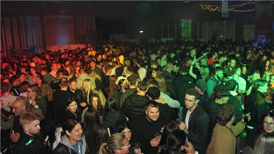 Große Menschenmenge auf einer Party oder Veranstaltung mit bunter Beleuchtung