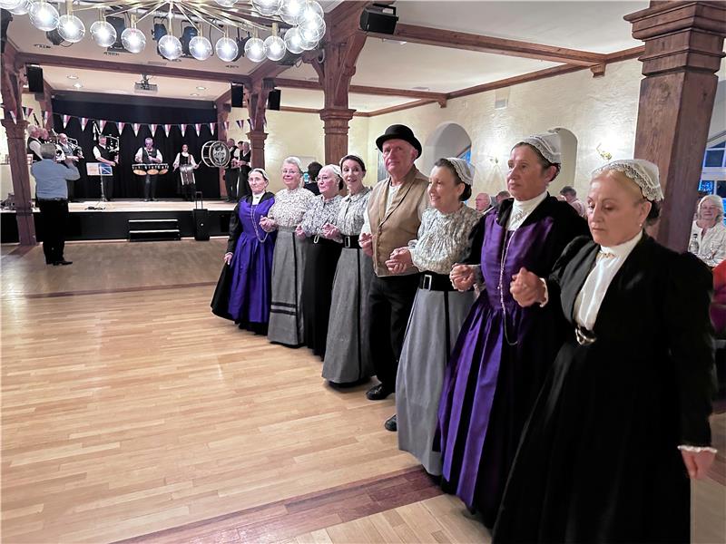 Die Tanzgruppe Galets Jade zeigt zur Musik von Bro Kervignac (auf der Bühne) bretonische Volkskunst. Aus Bad Harzburg tragen zudem Paare des CTC Rot-Gold etwas zum kulturellen Rahmen des Abschiedsabends bei, an dem auch noch Gesang erklingt. Foto: Schlegel