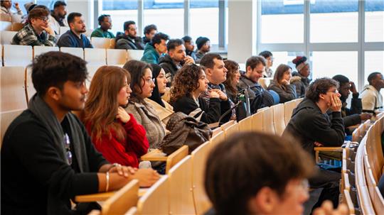 Viele junge Menschen sitzen in einem Hörsaal.