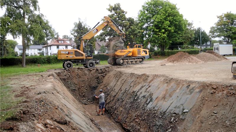 Ein Bagger gräbt einen Graben.