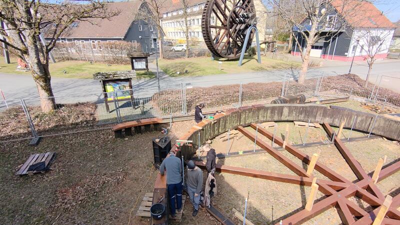 Die Tischler-Lehrlinge sammeln Praxiserfahrung bei der Sanierung des Kunstrads. Im Hintergrund ist das Kehrrad zu sehen, das bereits vor drei Jahren restauriert wurde.