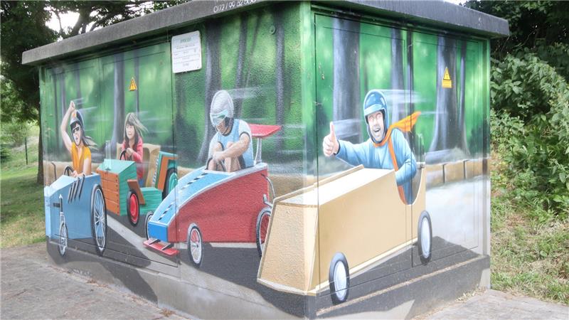 Zum 25. Mal starten tollkühne Piloten in rollenden Seifenkisten Die Trafostation im Dorf hat als Motiv das Seifenkistenrennen – der Ort schaffte es damit in einen Avacon-Kalender.