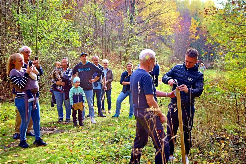 Die Väter haben die Ehre, die Namensschilder ihrer Kinder an die Pfosten neben den jungen Bäumen anzunageln. Foto: Jung