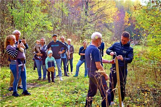 Die Väter haben die Ehre, die Namensschilder ihrer Kinder an die Pfosten neben den jungen Bäumen anzunageln. Foto: Jung