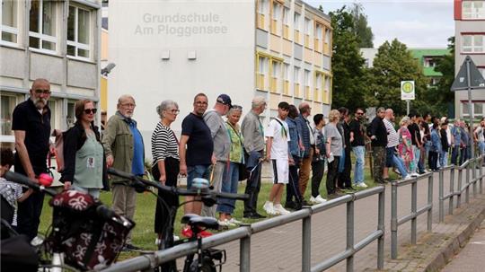 Die Veranstalter sprachen von rund 500 Teilnehmern, die sich mit bunten Bändern zu einer Kette verbunden hatten.