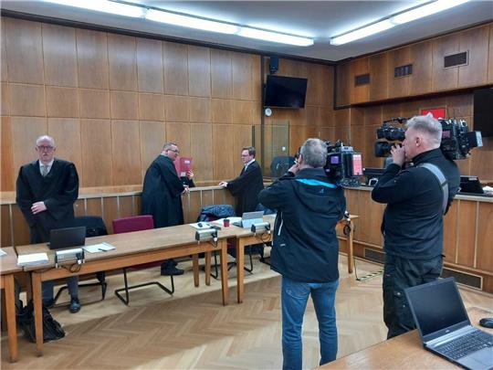 Die Verteidiger Raban Funk (re.) und Pascal Ackermann stehen bei ihrem Mandanten (mit roter Mappe verdeckt). Foto: Neddermeier