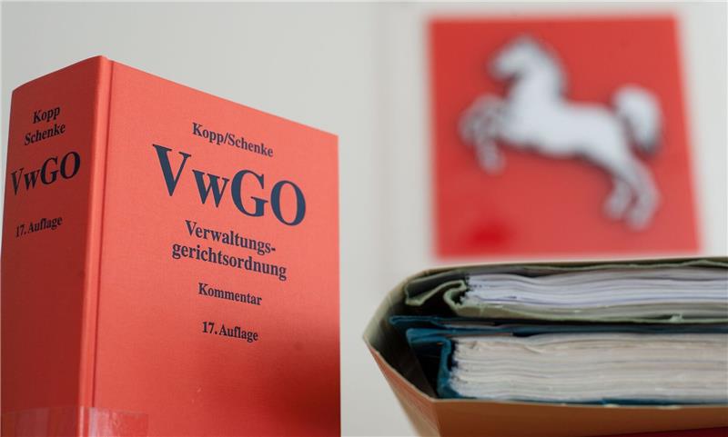 Die Verwaltungsgerichtsordnung steht neben Akten im Niedersächsischen OVG auf einem Tisch.