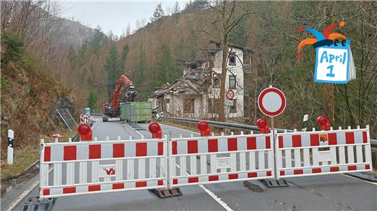 Das Foto zeigt im Vordergrund die mit weiß-roten Baken gesperrte B 498. Im Hintergrund befördert ein Bagger Trümmer der eingerissenen "Villa Helene" in einen grünen Container.
